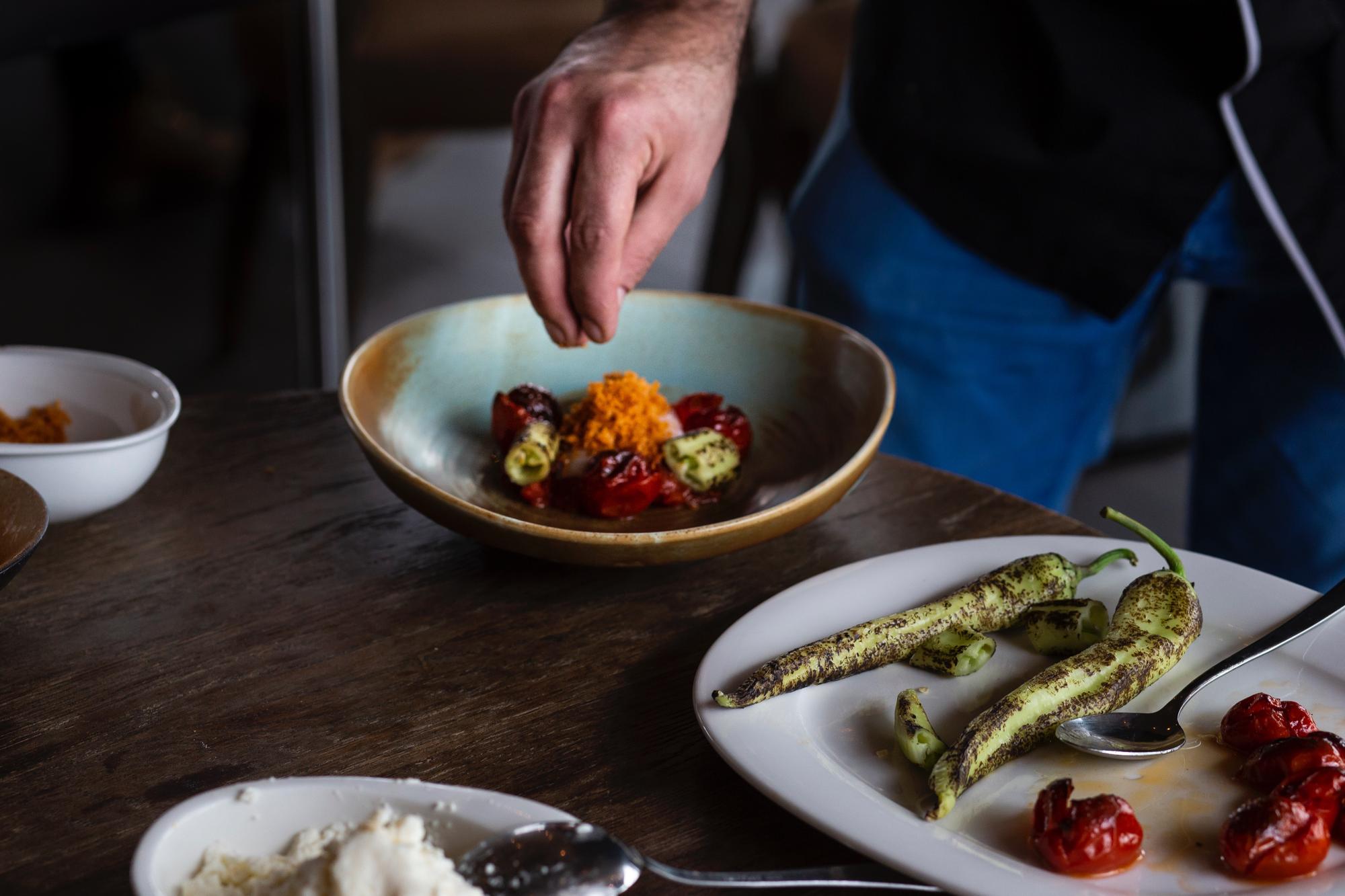Chef preparing a composed dish on wooden table